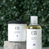 All natural body butter and luxurious body oil with visible brand logo against a green foliage background.