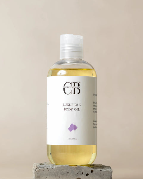 Bottle of luxury body oil on a beige background
