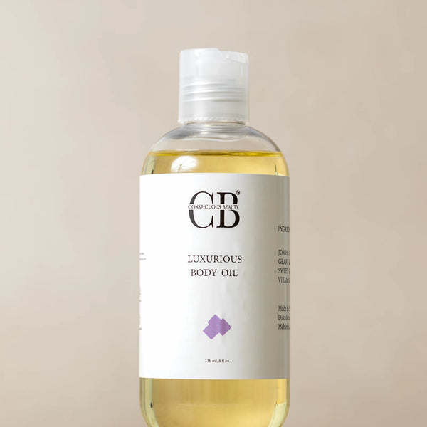 Bottle of luxury body oil on a beige background